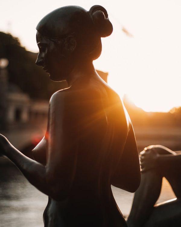 Woman in a peaceful morning pose with a bronze glow